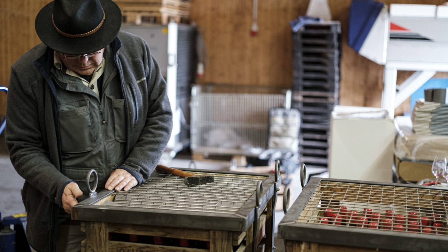 Die Holzkisten werden in Metallkäfige eingespannt, die mit Aufhängepunkten versehen sind, die das Eintauchen erleichtern.